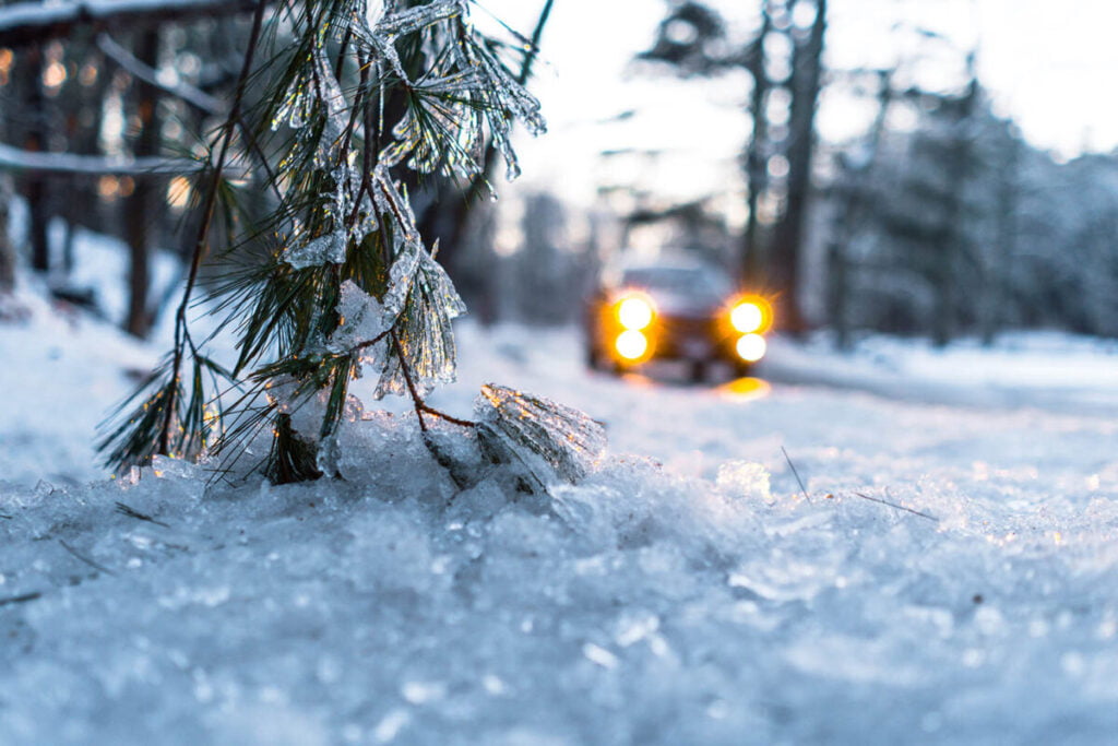 Car with headlights on passing through frozen road - navigate freezing conditions safely - Behind the Scenes NYC