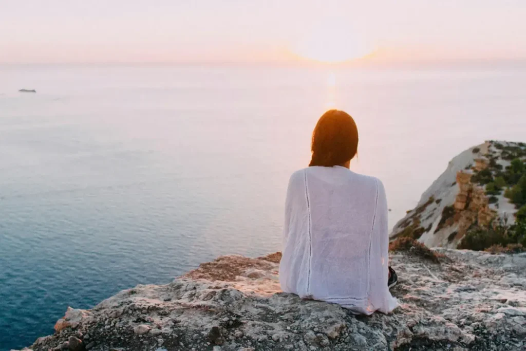 A woman looking at water and thinking about gentle retreats near NYC